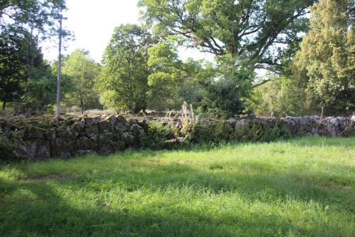 a stone wall in a field with green grass at Yxkullsund Säteri B&B - Manor & Estate since 1662 in Lagan