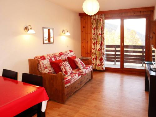 ein Wohnzimmer mit einem Sofa mit roten und weißen Kissen in der Unterkunft Appartement Les Orres, 2 pièces, 4 personnes - FR-1-322-130 in Les Orres