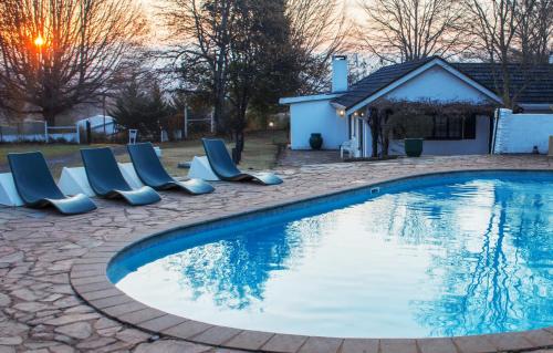 a swimming pool with lounge chairs next to a house at Himeville Arms in Himeville