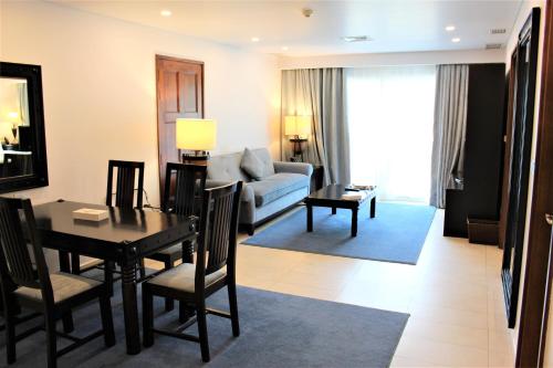 a living room with a table and a couch at Mövenpick Hotel & Resort Al Bida'a in Kuwait