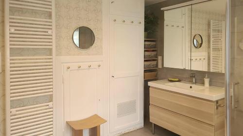 a white bathroom with a sink and a mirror at Superbe maison avec jardin magnifique! in Schiltigheim