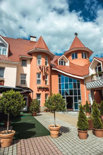 フーストにあるV&P HOTEL & Restaurantの前に木々がある大きな建物