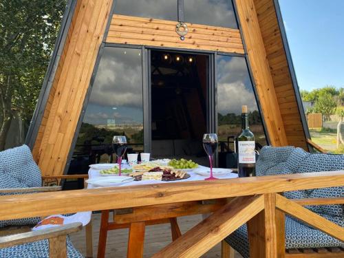 un tavolo con bicchieri da vino e cibo su una terrazza di Lake View Bungalow Close to Airport a Arnavutköy