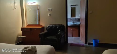 a room with a black chair and a mirror at Hotel hornbill in Sauraha