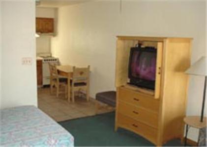 1 dormitorio con cama y vestidor con TV en Miles Motel en Mesa