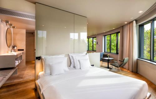 a bedroom with a large white bed and windows at SANA Berlin Hotel in Berlin