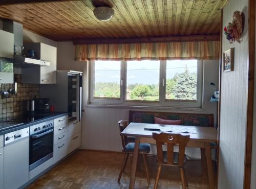 a kitchen with a table and chairs and a window at Ferienwohnung Haus Gatternig in Seeboden