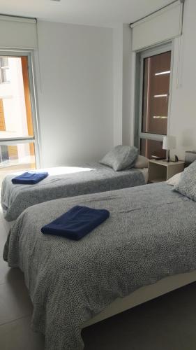 two beds in a room with blue towels on them at Casa de Playa Sol Y Mar in El Médano