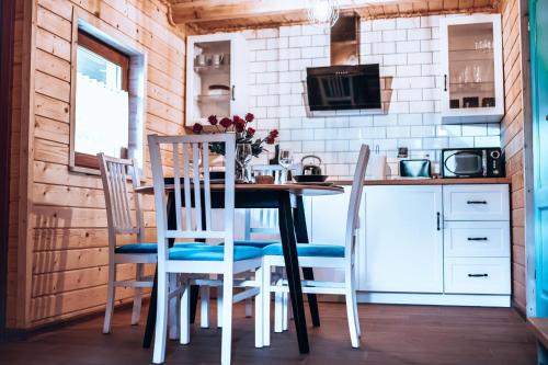 eine Küche mit einem Tisch und Stühlen in einer Hütte in der Unterkunft Dychnij Se in Szczyrk