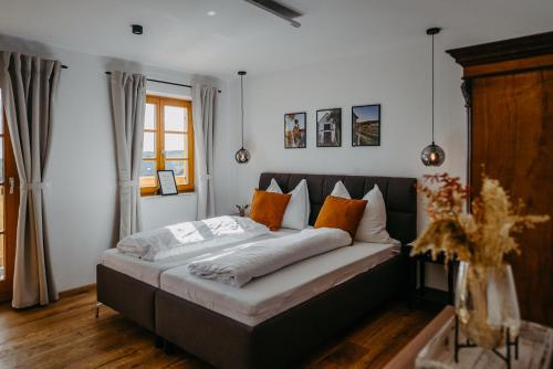 1 dormitorio con 1 cama con almohadas de color naranja y blanco en Kellerstöckl Huber in Eisenberg, en Eisenberg an der Pinka
