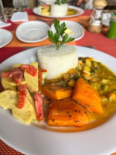a plate of food with meat and vegetables on a table at Bwindi Forest Lodge in Buhoma