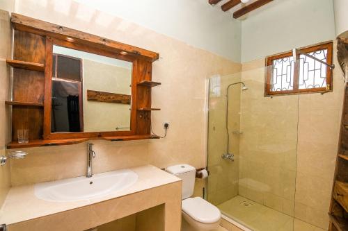 a bathroom with a sink and a shower and a toilet at Majani Breeze in Nungwi