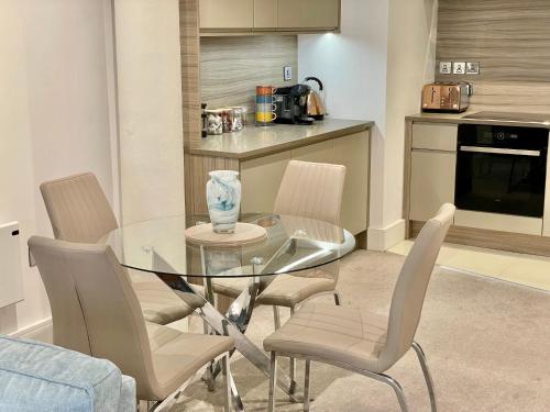 a dining room with a glass table and chairs at The Butler Suite in York