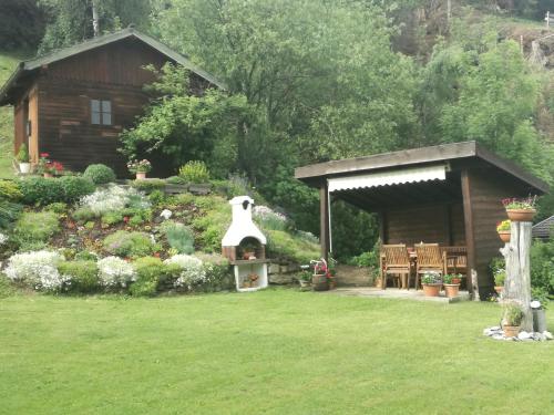 einen Garten mit einer Holzhütte mit einem Vogelhaus in der Unterkunft Bichlerhof in Hopfgarten in Defereggen