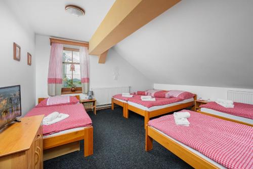 um quarto com quatro camas e uma televisão em Svět pod Ještědem em Hoření Paseky