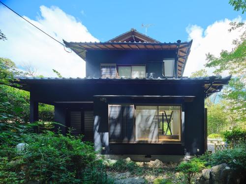 una casa negra con una ventana delante en Villa Fuji-fumoto -富士宮 麓のヴィラ- 