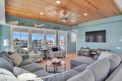 Una sala de estar con sofás y un televisor de pantalla plana. en Nauti Beach, en Port Aransas