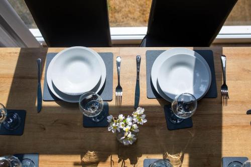 a wooden table with plates and silverware on it at Badger's Rest-parking included, lockable rooms 