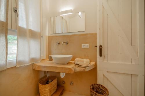 ein Bad mit einer Schüssel auf einer Theke neben einer Tür in der Unterkunft Villa Elicriso Charme e Nature-Goelba in Portoferraio