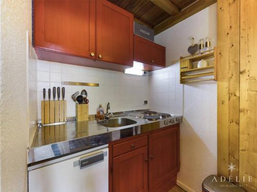 une petite cuisine avec un évier et une cuisinière dans l'établissement Studio mezzanine rénové 4 pers, balcon, 80m des pistes, proche commerces - Montvalezan - FR-1-398-597, à La Rosière