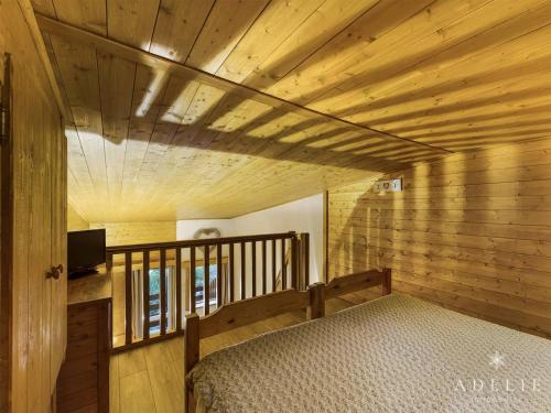 Cette chambre comprend un lit et un plafond en bois. dans l'établissement Studio mezzanine rénové 4 pers, balcon, 80m des pistes, proche commerces - Montvalezan - FR-1-398-597, à La Rosière