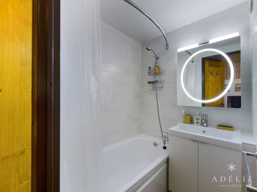 une salle de bain blanche avec un lavabo et un miroir dans l'établissement Studio mezzanine rénové 4 pers, balcon, 80m des pistes, proche commerces - Montvalezan - FR-1-398-597, à La Rosière