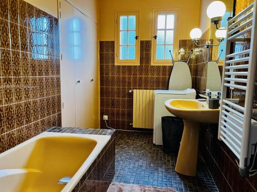 łazienka z żółtą wanną i umywalką w obiekcie Maison T4 à Cambo-les-Bains: 5 couchages, jardin arboré, balcon, cheminée, animaux acceptés, Wi-Fi fibre - FR-1-495-114 w mieście Cambo-les-Bains