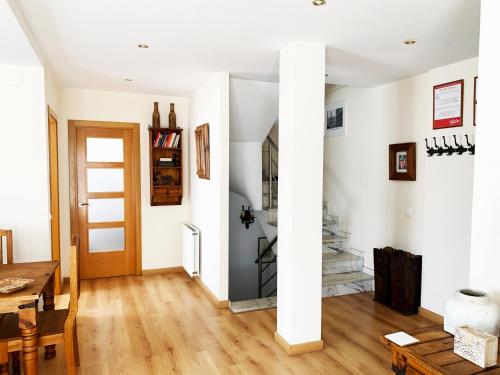 sala de estar con paredes blancas y suelo de madera. en Casa Román III, en Gijón