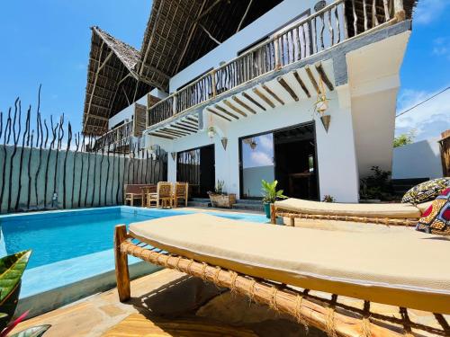 a villa with a swimming pool and a resort at Chunga Changa in Matemwe