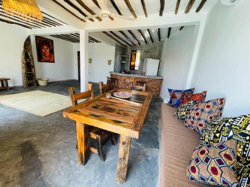a living room with a wooden table and a couch at Chunga Changa in Matemwe