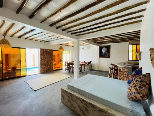 a living room with a bed and a dining room at Chunga Changa in Matemwe