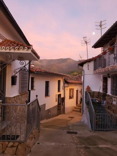 un vicolo con case e montagne sullo sfondo di Casa Rural La Severina a Hervás