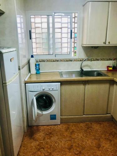 a kitchen with a washing machine and a sink at Piso Alicante in Alicante
