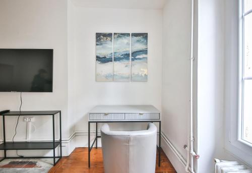Cette chambre blanche dispose d'une table et d'une télévision. dans l'établissement 22#Appartement 6Pers#Sèvres-Lecourbe#Necker, à Paris