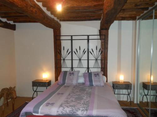 ein Schlafzimmer mit einem Bett mit zwei Kerzen auf zwei Tischen in der Unterkunft Belle demeure Normande dans son écrin de verdure. in Manneville-sur-Risle