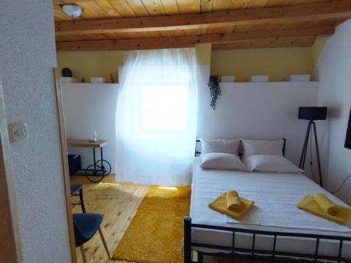 Un dormitorio con una cama con almohadas amarillas. en Apartments Elena & Damir, en Vis