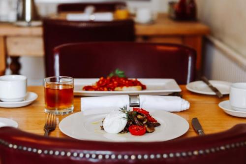 a table with plates of food and a glass of juice at Arosfa Harbourside Aberaeron in Aberaeron