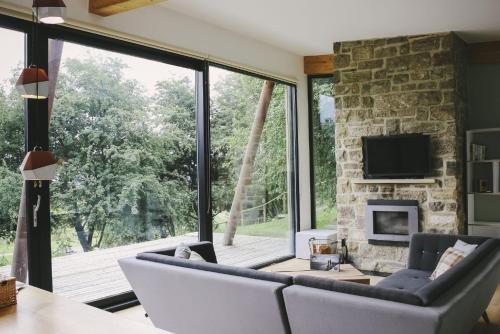 a living room with a large window and a fireplace at Yorkshire Dales Lodge 7 by Together Travel - 3-Bed Premium Ensuite Retreat in Richmond