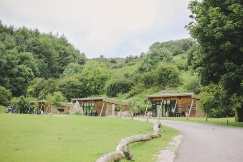 a log laying on the grass in front of a building at Yorkshire Dales Lodge 7 by Together Travel - 3-Bed Premium Ensuite Retreat in Richmond