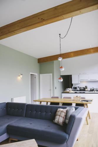 a living room with a blue couch and a table at Yorkshire Dales Lodge 7 by Together Travel - 3-Bed Premium Ensuite Retreat in Richmond