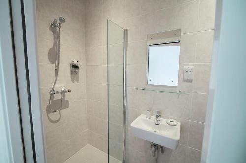 uma casa de banho com um chuveiro, um lavatório e uma cabina de duche em vidro. em Yorkshire Dales Lodge 7 Premium Ensuite em Richmond