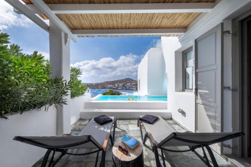 a patio with a table and chairs on a balcony at Deliades Hotel in Ornos