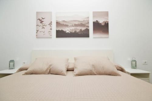a bedroom with a bed with three pictures on the wall at El Charco I - By AZ Rentals in Arrecife