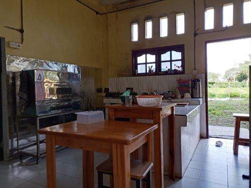 a kitchen with a wooden table and a stove at Berastagi Mountain View Homestay & Pizzeria in Berastagi