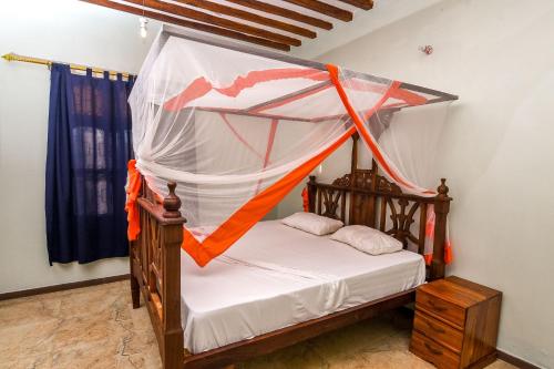 a bedroom with a bed with a mosquito net at Majani Breeze in Nungwi