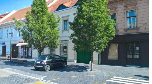 a small car parked in front of a building at Belváros Apartmanház Sopron in Sopron