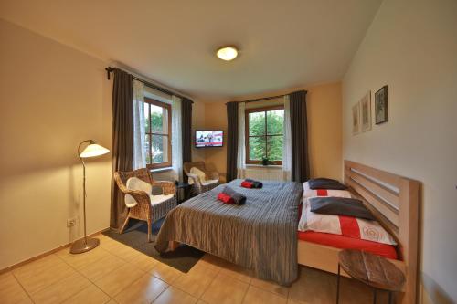 ein Schlafzimmer mit einem Bett und ein Zimmer mit einem TV in der Unterkunft Apartmány U šneka in Železná Ruda