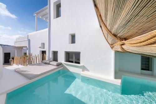 a villa with a swimming pool and a house at Deliades Hotel in Ornos