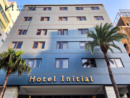 a hotel with palm trees in front of it at Hotel Initial-Taichung in Taichung