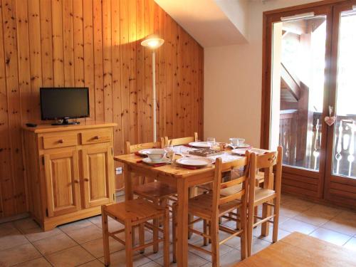 une salle à manger avec une table, des chaises et une télévision dans l'établissement Duplex 3 Pièces 6 couchages à 100m des pistes, Vars Les Claux - FR-1-330B-37, à Vars